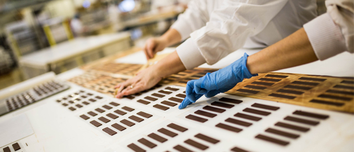 Dos empleados de PCB Création confeccionando pastillas de chocolate